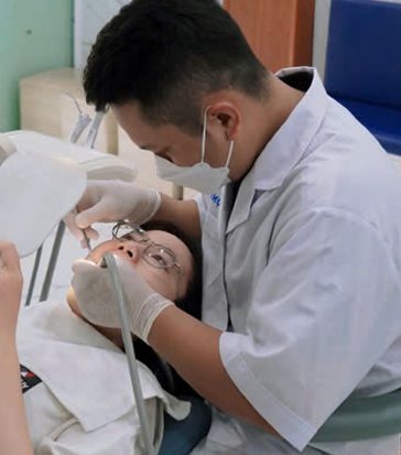 Bác sĩ đang điều trị cho khách hàng bằng thiết bị tại ghế